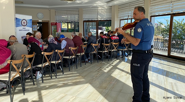 Polis memurunun belinde silah, omzunda keman