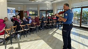 Polis memurunun belinde silah, omzunda keman